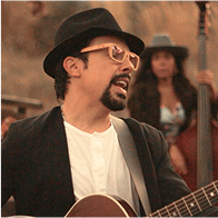 Julio César tocando la guitarra en el campo junto a The Band