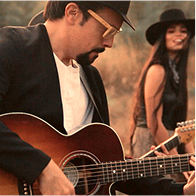 Julio César tocando la guitarra en el campo junto a The Band