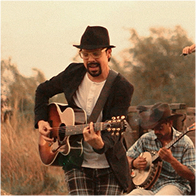 Julio César tocando la guitarra en el campo junto a The Band