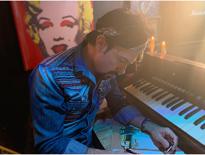 Julio César escribiendo una cancion junto al piano